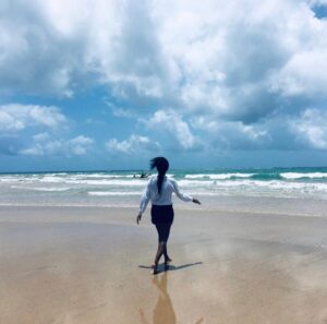 Woman walking on the beach towards the ocean